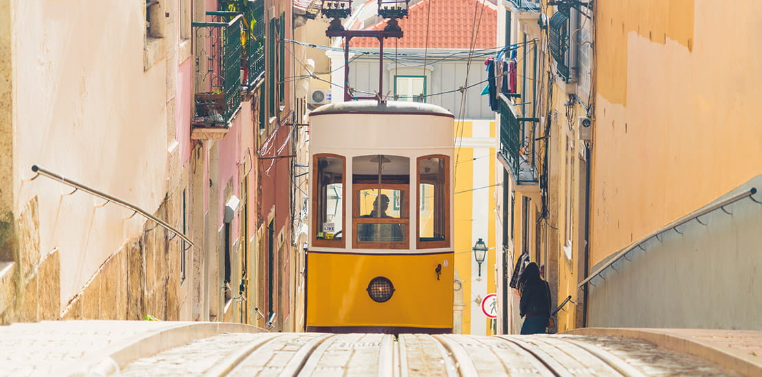 A tram travelling down a street in Lisbon, Portugal